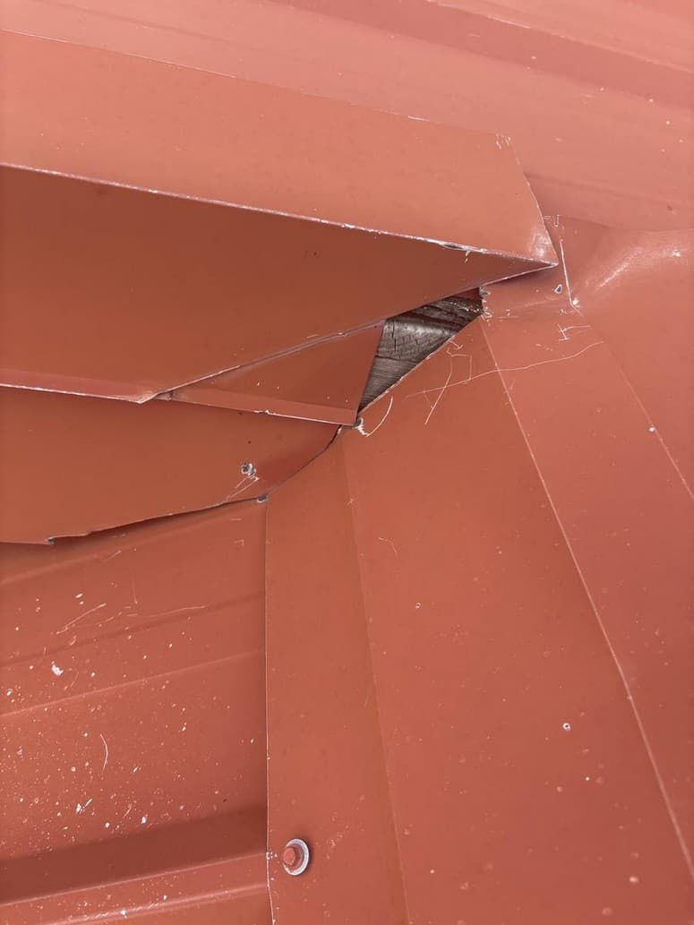 Photo 1 — Garage corner. Metal does not meet. Wood in the hole.