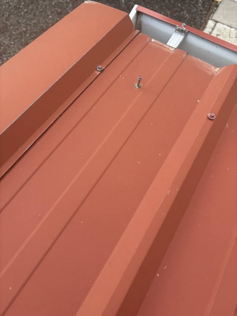 Photo 6 — Screw standing up near the eave. Threads showing. Washer not tight.