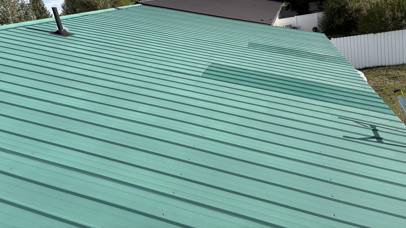 Green metal panels fastened on a roof